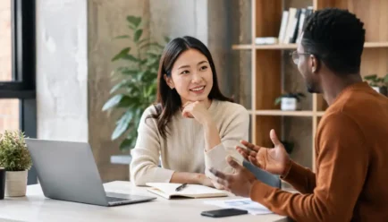 Two diverse professionals having a friendly workplace conversation while discussing and agreeing on an idea.