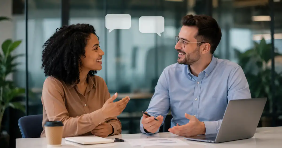 Two diverse professionals having a friendly office discussion and agreeing with each other, with subtle speech bubbles and a modern workspace in the background.