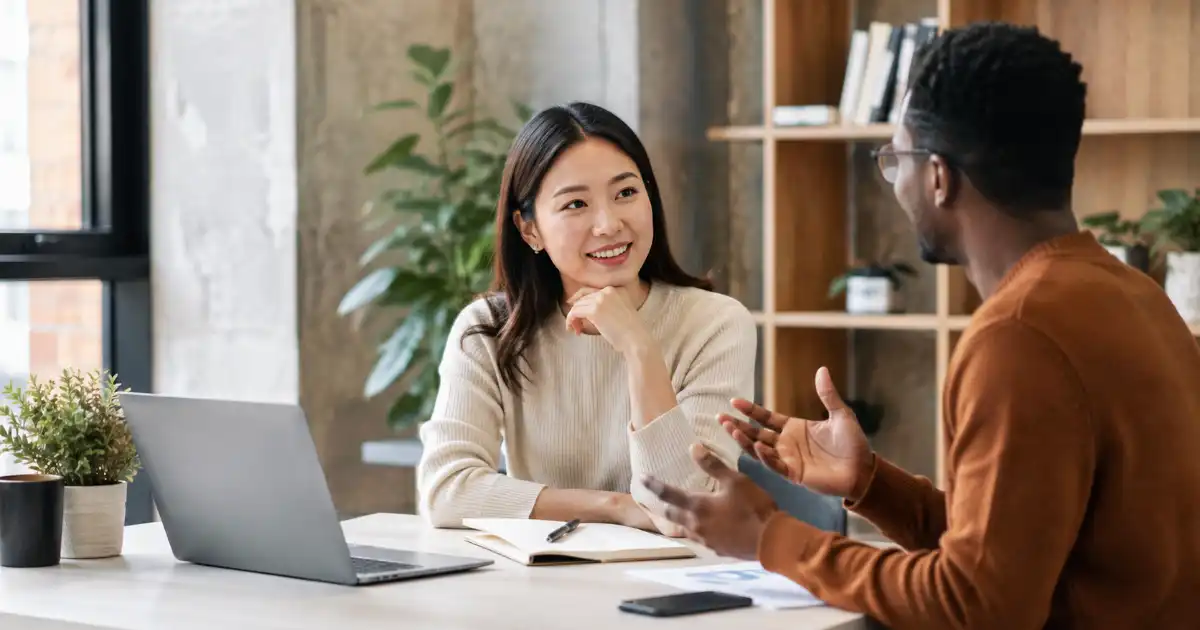 Two diverse professionals having a friendly workplace conversation while discussing and agreeing on an idea.