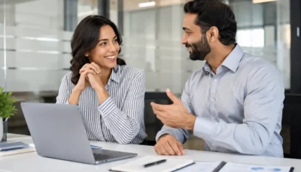 Two diverse professionals sharing positive feedback and encouragement during a successful workplace discussion