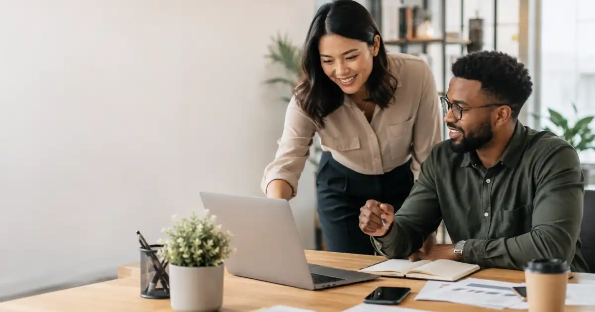 Two diverse professionals collaborating on a project in a modern office, representing teamwork, positive impact, meaningful contribution, and effective communication.