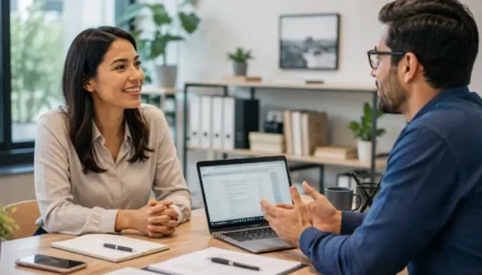 Two professionals having a friendly office conversation while sharing useful information and practicing clear workplace communication.